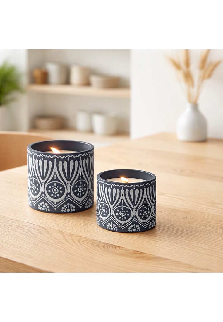 Zwei J-LINE Kerzen Terracotta im Set, Frontansicht, dunkelgrau mit weissgemustertem Rand. Die Kerzen sind beleuchtet und stehen auf einem Holztisch.