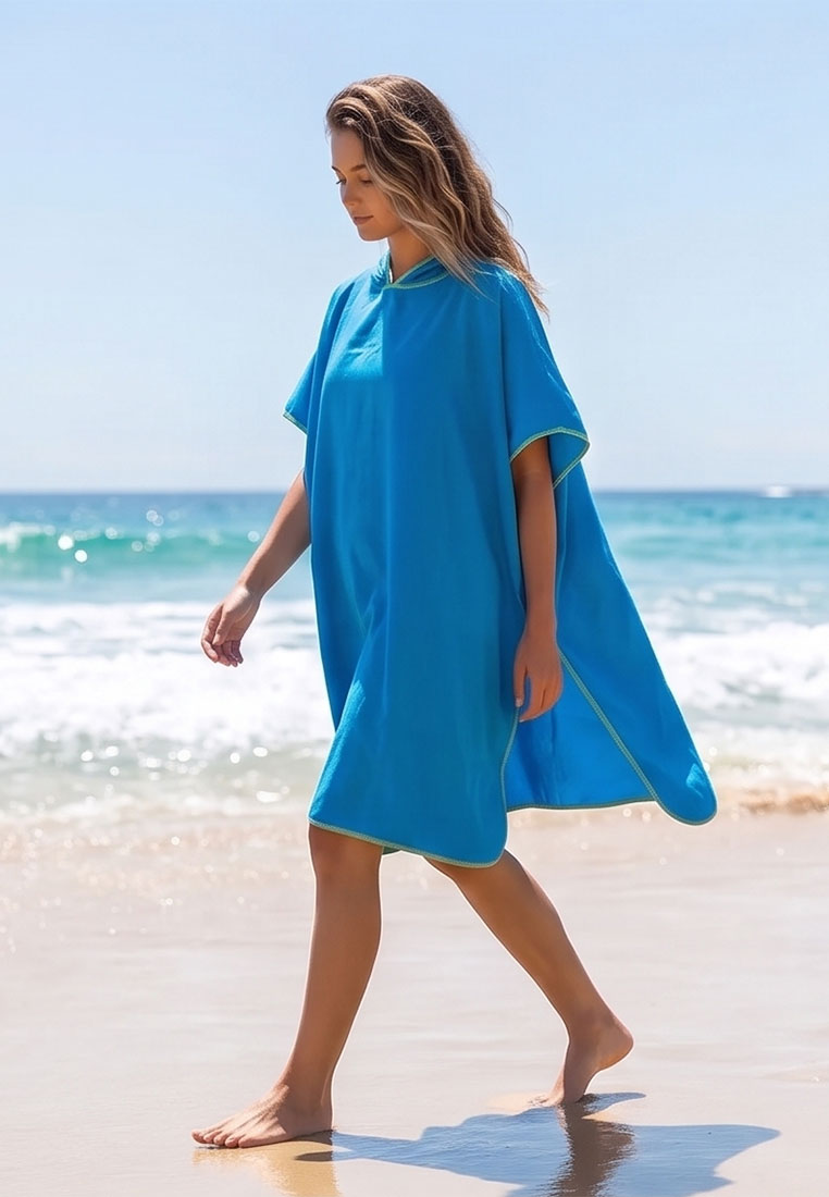 Home sweet Home Mikrofaser Umziehponcho blau, Frontansicht auf einem Strand. Der Poncho hat kurze Ärmel und eine Kapuze.