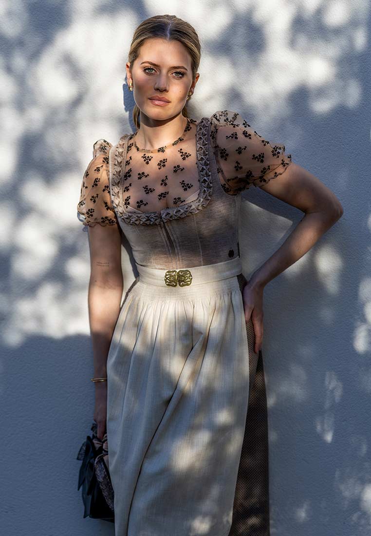 MarJo Trachten Dirndl Polling sand 70 cm in Frontansicht. Das elegante Dirndl ist sandfarben mit Puffärmeln aus schwarzem Blumenmuster und einem schmucken Gürtel.
