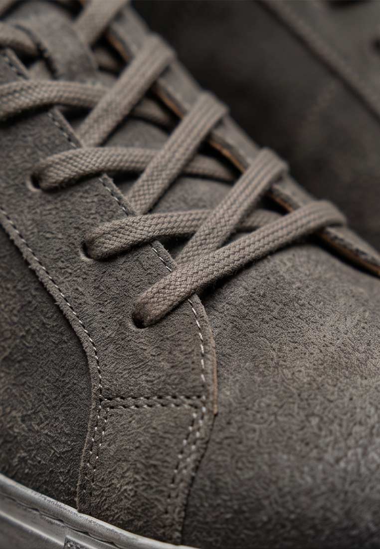 Detailansicht der braunen MeiSchua Trachtensneaker Mei bajra, mit sichtbaren Schnürsenkeln und Nähten.