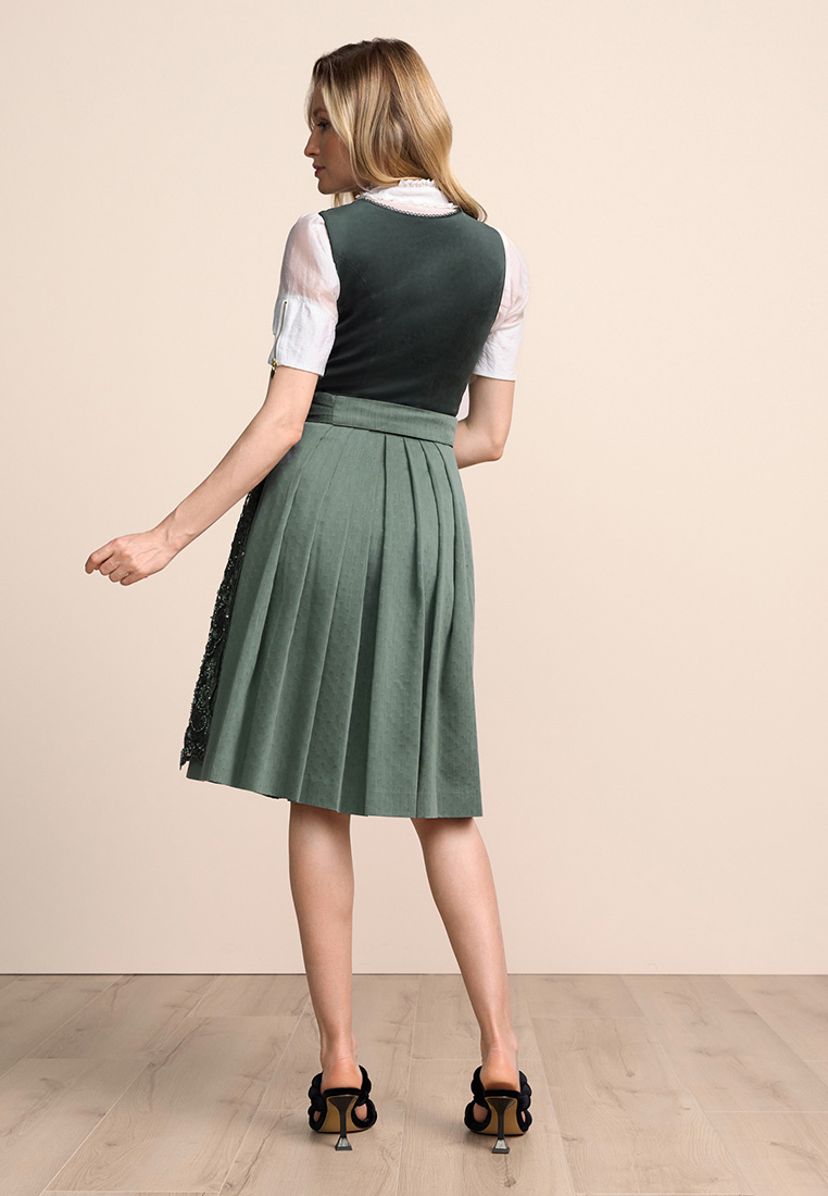 Rückansicht eines dunkelgrünen Dirndls Elira von Krüger mit einem kurzärmligen weißen Oberteil und einem geraden Rock.