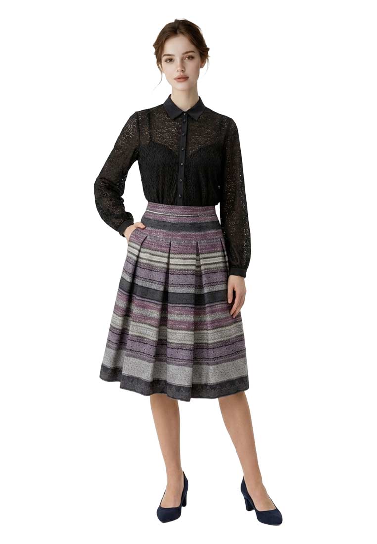 Marjo Body Harper Malinda schwarz, Frontansicht eines eleganten schwarzen Spitzen-Bodys mit farbigen Streifenrock und Hand in der Tasche.