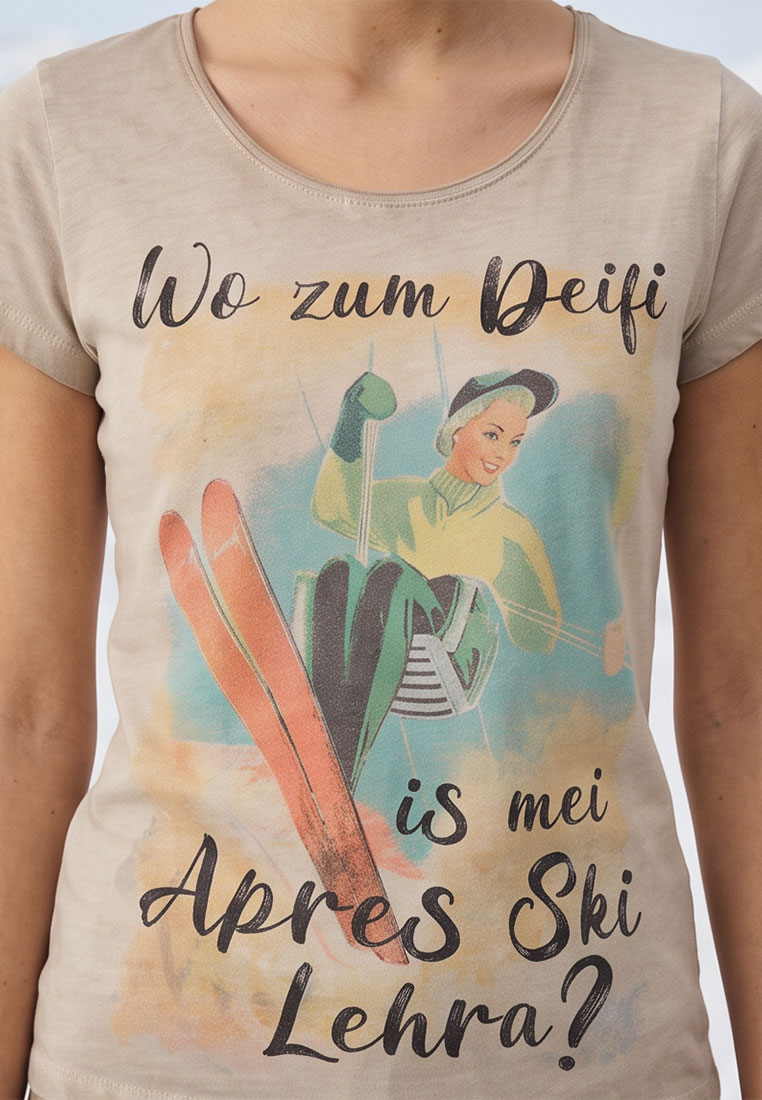 Hangowear Damenshirt Apres Ski, Frontansicht in Beige. Das Shirt zeigt eine Retro-Grafik mit einer Skifahrerin und Skiern sowie den Schriftzug 'Wo zum Deifi is mei Apres Ski Lehra?'.