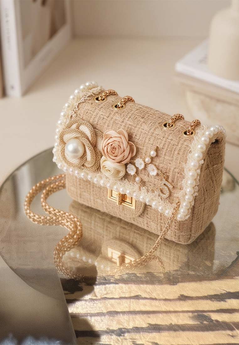 Schmuckzauber Tweed Trachtentasche Glamour Romantik beige im Frontansicht mit goldenen Ketten und Perlenbesatz.