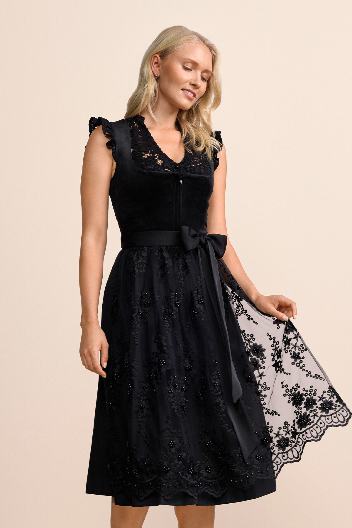 Krüger Dirndl Lovira schwarz 60cm, Frontansicht. Elegantes schwarzes Dirndl mit Schnürung, Spitzendetails am Dekolleté und Verzierungen auf dem Rock.