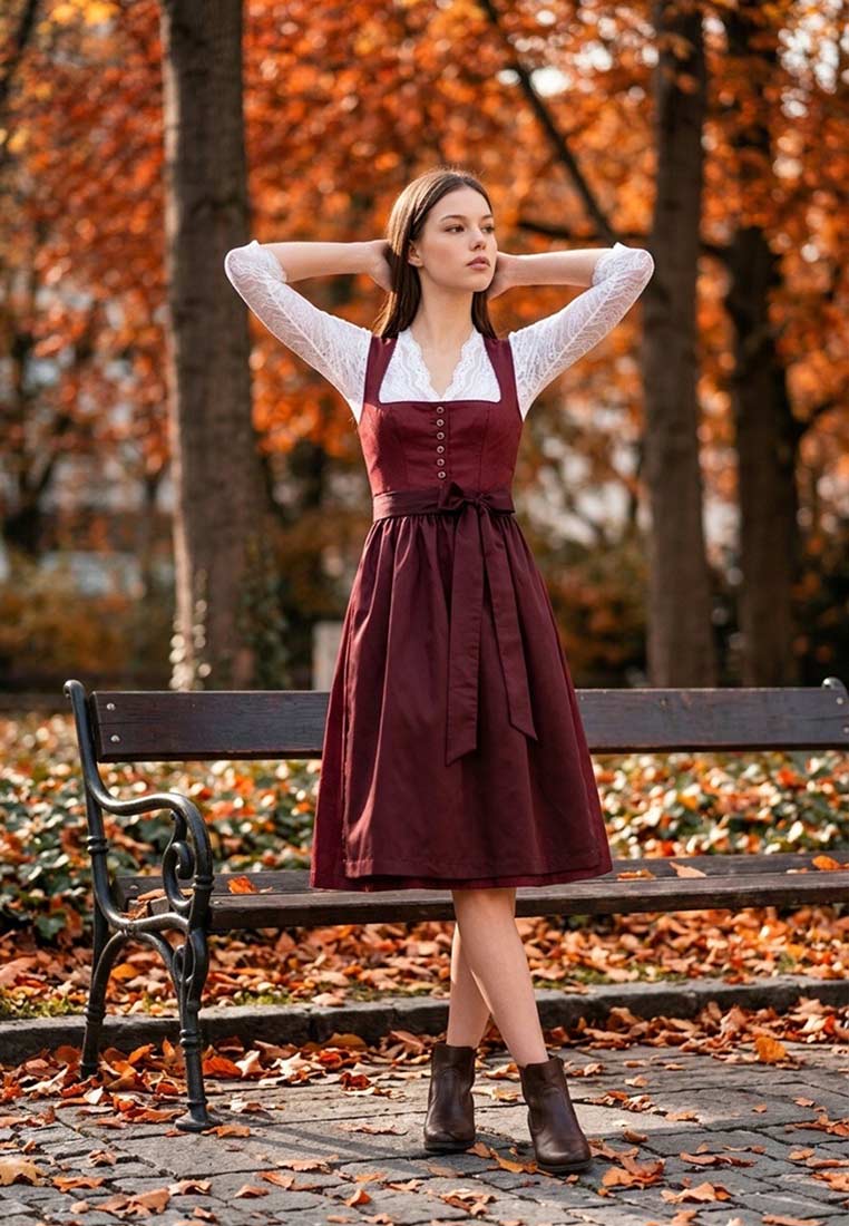 MarJo Trachten Dirndl Vordernberg, kastanienrotes Dirndl mit weißer Bluse, Frontansicht. Das Kleid hat eine Schnürung vorne und einen gebundenen Gürtel.