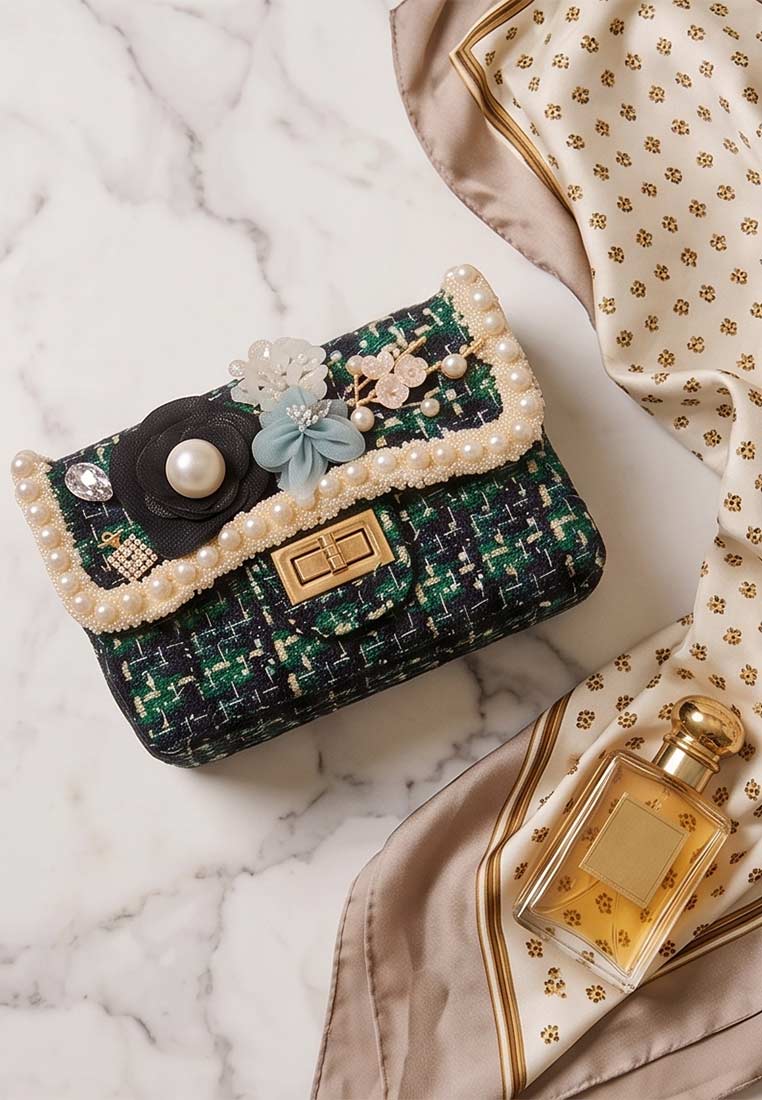 Frontansicht der Schmuckzauber Tweed Trachtentasche Glamour in Grün mit Perlenbesatz und Blumenapplikationen, vorne mit goldfarbenem Verschluss.