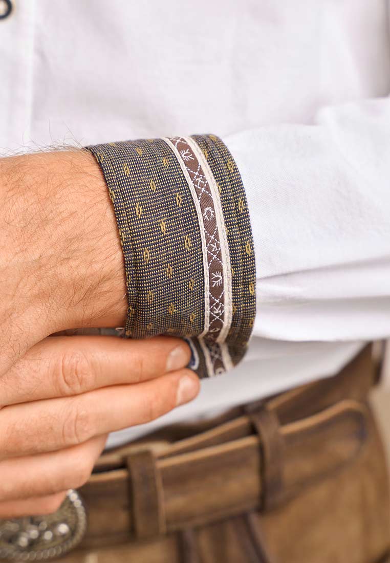 Krüger Trachtenhemd Ryan in Weiss Braun. Nahaufnahme der Manschette mit Stoffmuster und Borte in braunen und gelben Tönen.