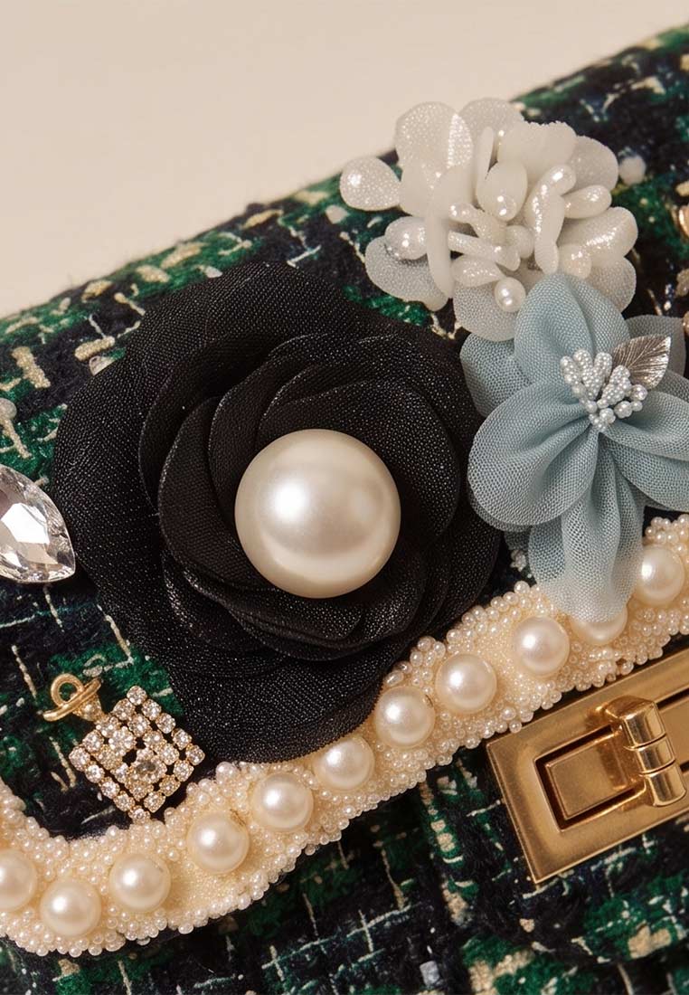Schmuckzauber Tweed Trachtentasche Glamour grün, Detailansicht mit schwarzen und blauen Blumenapplikationen, Perlenbesatz und goldfarbenem Verschluss.