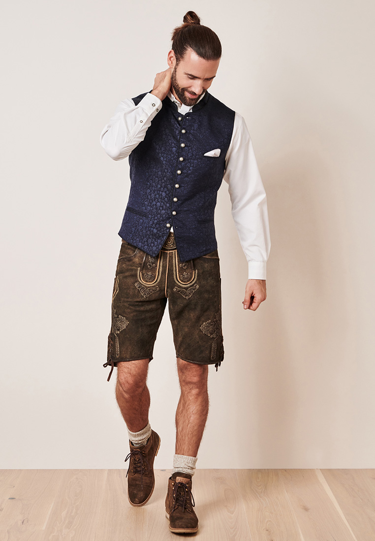 Krüger Trachtenweste Juanito marine: Frontansicht einer dunkelblauen Trachtenweste mit Knopfleiste und aufgesetzten Taschen, getragen von einem Mann.