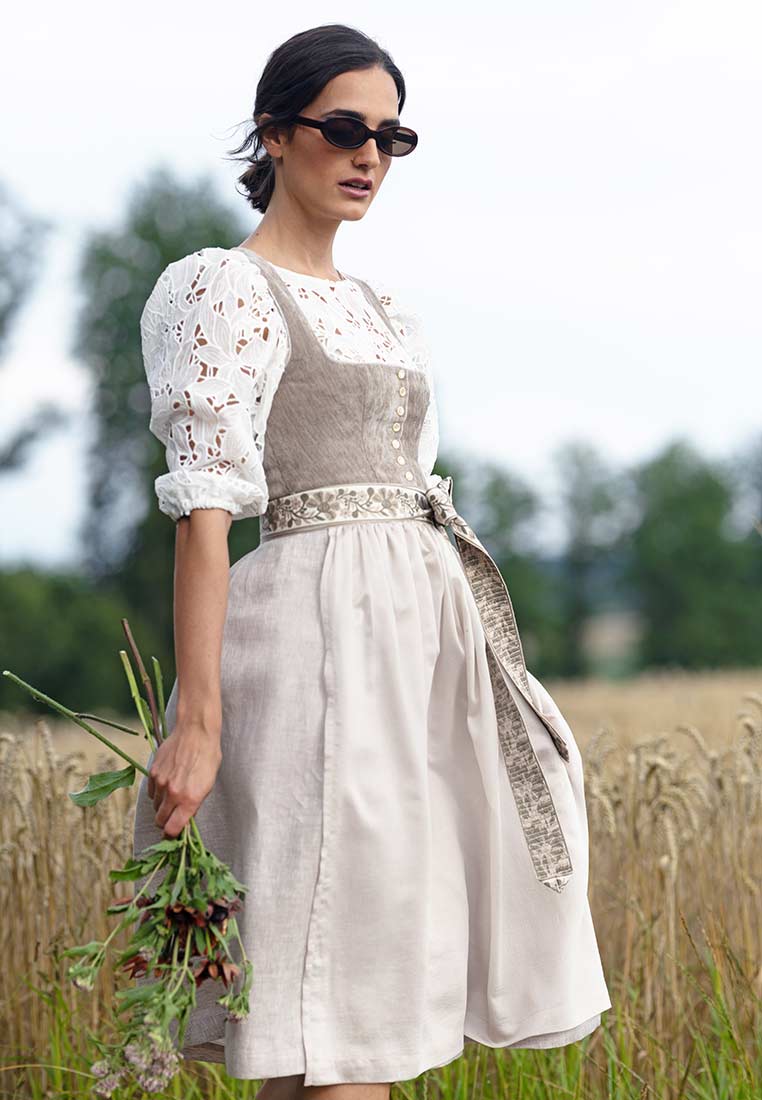 Marjo Dirndl Leopoldsdorf taupe 65 cm, Frontansicht. Das Dirndl zeigt eine hellbraune Miederpartie mit Knöpfen und eine naturfarbene Schürze.
