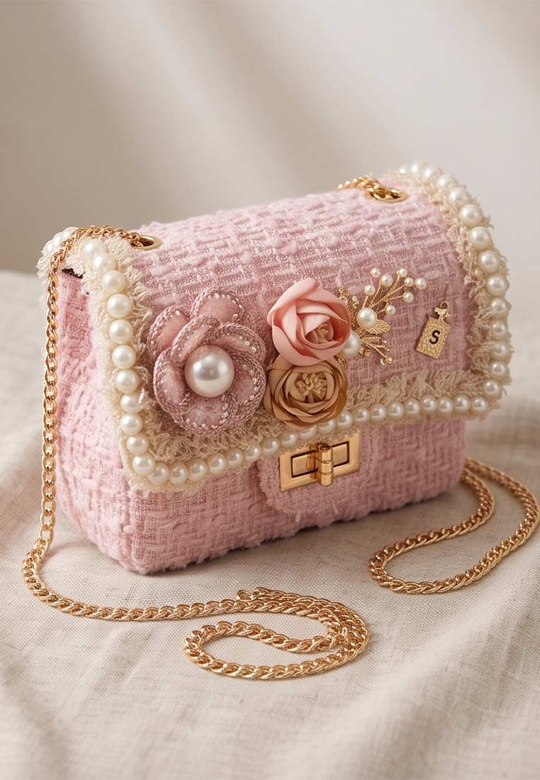 Schmuckzauber Tweed Trachtentasche Glamour rosa im Frontalansicht, verziert mit Perlen, Blumen und einer goldenen Kette. Die Tasche ist in einem zarten Rosa gehalten.