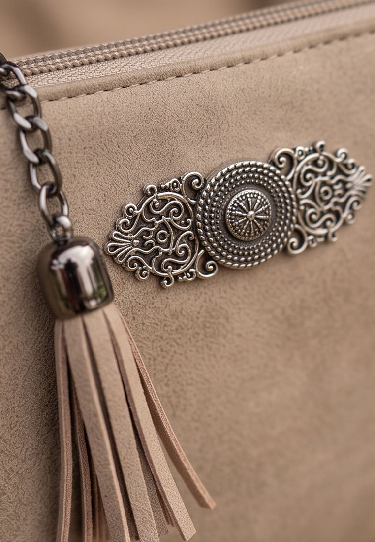 Detailansicht der Taschenzauber Trachtentasche Marie in Beige, mit sichtbarem Reissverschluss und dekorativem Anhänger mit Quaste.