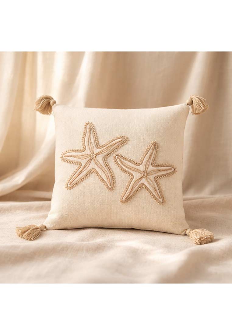 J-LINE Baumwollkissen Seestern in Beige, Frontansicht, mit zwei aufwendig gestickten Seesternen und dekorativen Quasten an den Ecken.