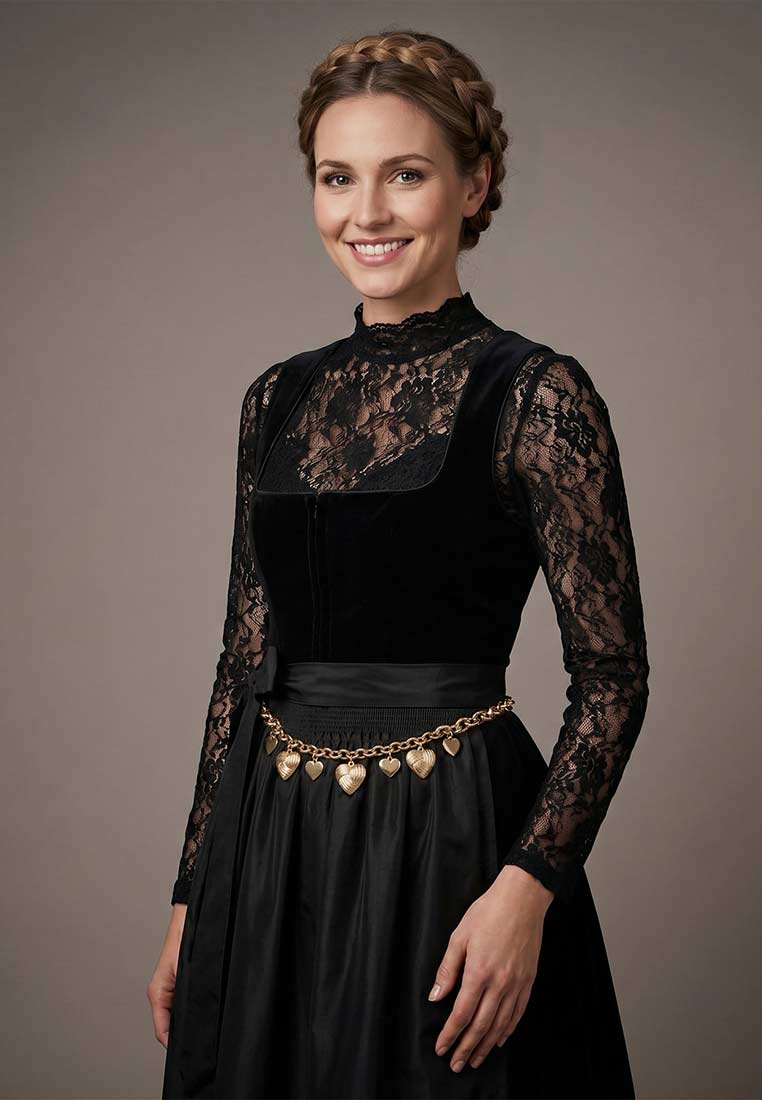Alpenflüstern Dirndl Schürzenkette Knotenherz gold, Frontansicht. Diese stilvolle goldfarbene Schürzenkette ziert einen breiten Bund und ist mit mehreren Herzen verziert.