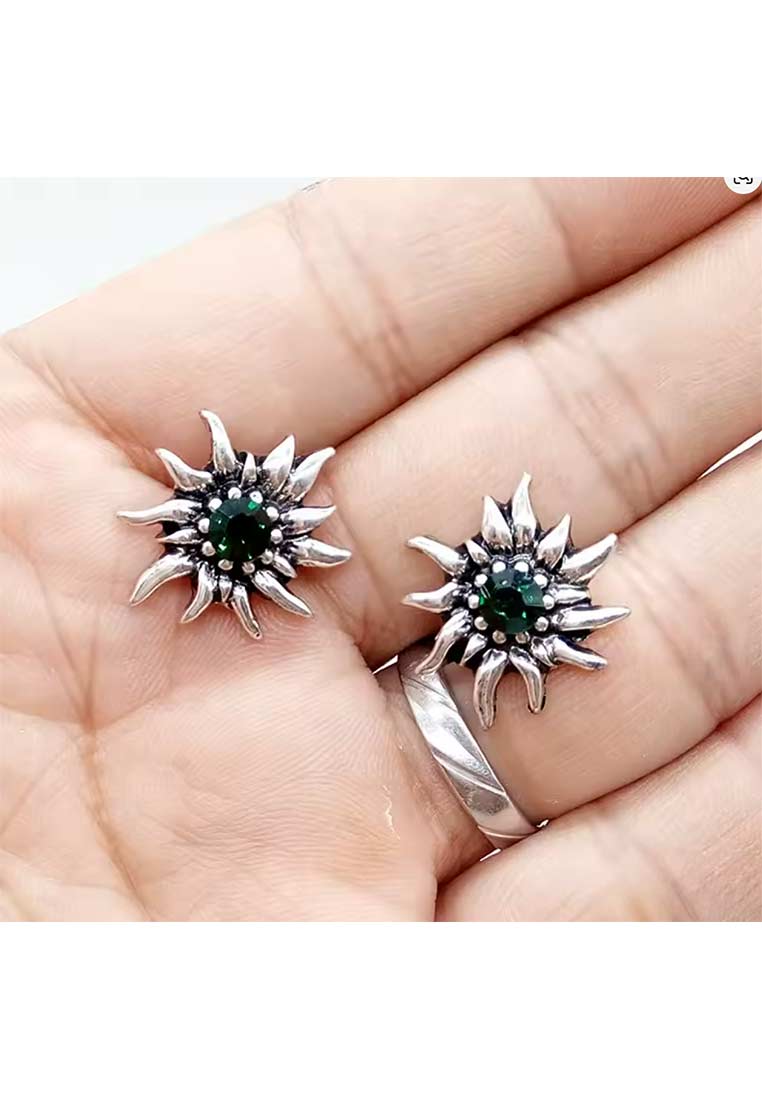Schmuckzauber Edelweiss Ohrstecker in flaschengrün mit silbernem Finish, als Frontansicht auf einer Hand liegend, mit sichtbaren Blütenblättern und einem zentralen Stein.
