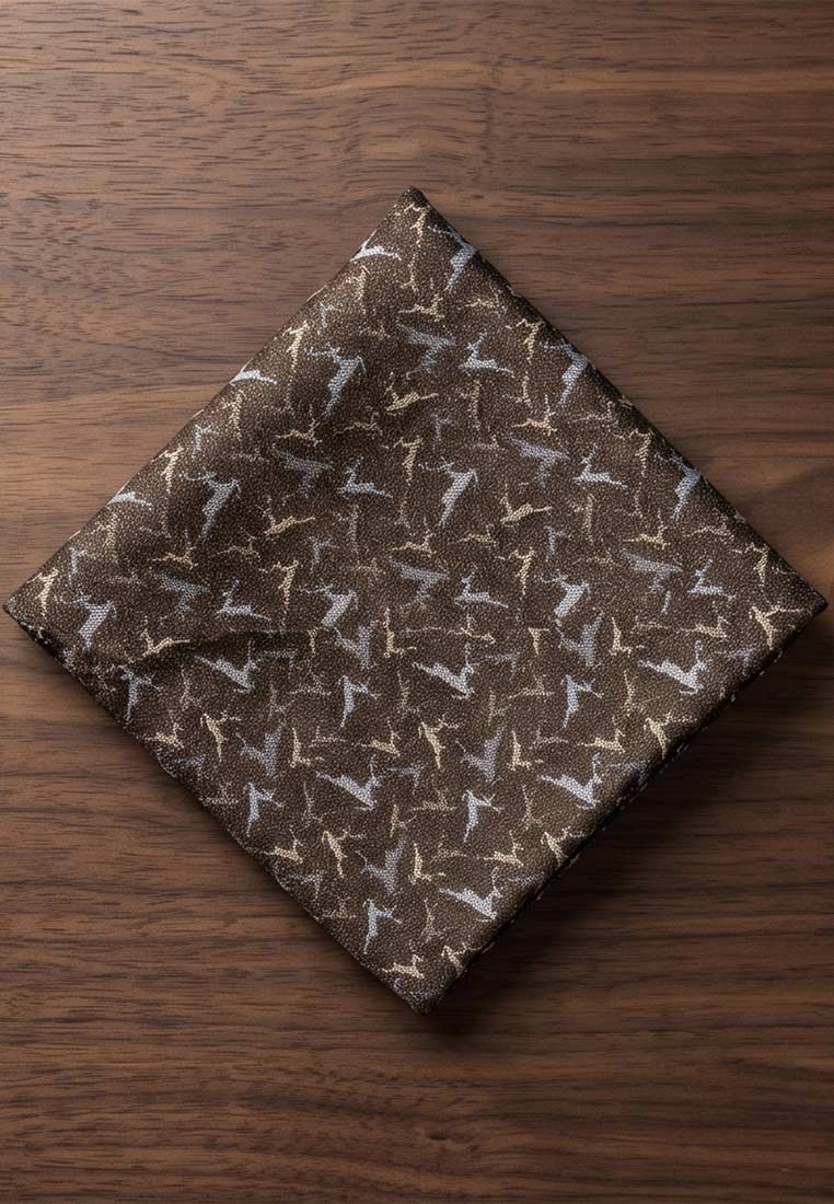 Luise Steiner Stecktuch kleine Hirsche taupe, Frontansicht. Das taupefarbene Stecktuch ist mit einem Muster aus kleinen Hirschen in Beige und Grau verziert und liegt auf einer Holzoberfläche.