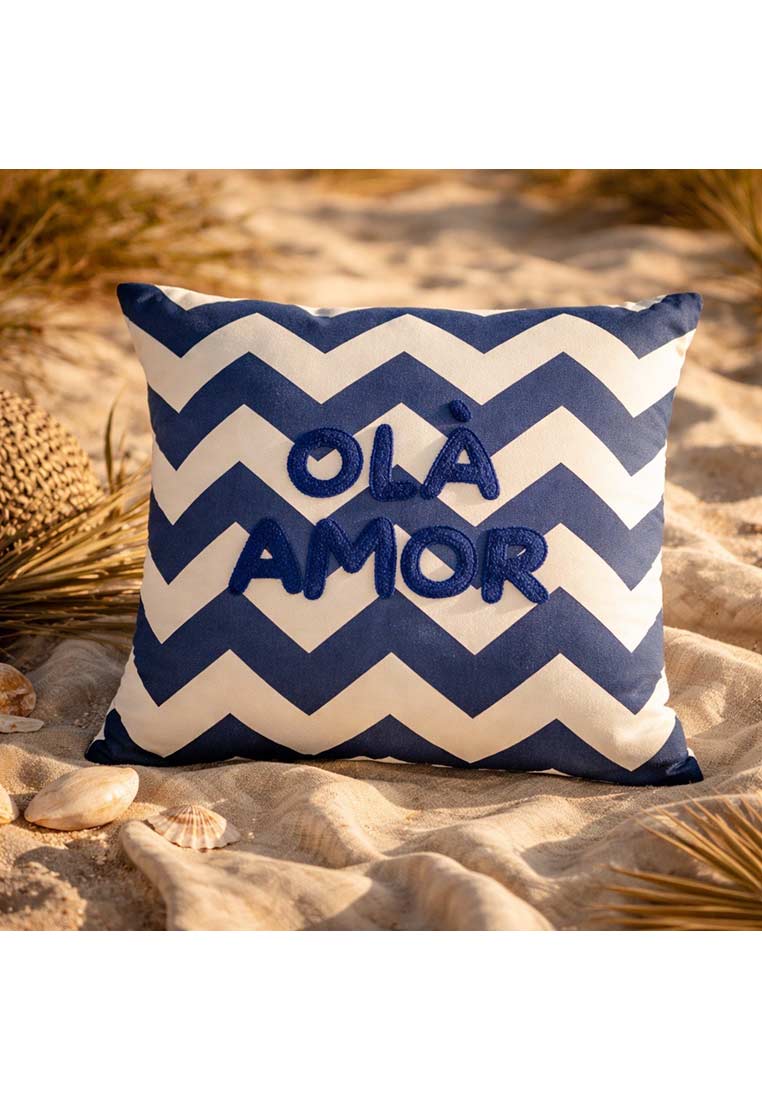 J-LINE Kissen Ola Amor in dunkelblau-weiß. Das Kissen zeigt ein Zickzackmuster und die Aufschrift 'OLA AMOR' in blauen Buchstaben.