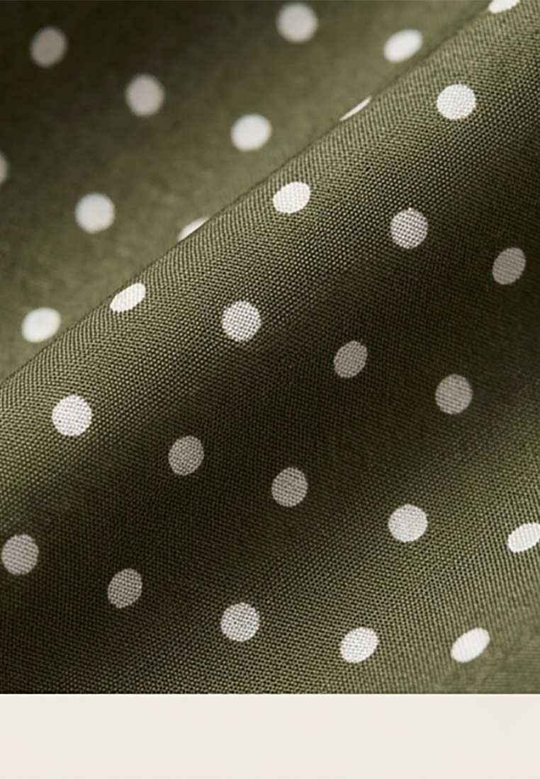 Schmuckzauber Nickituch Pünktchen olive mit weißem Pünktchenmuster in Nahaufnahme.