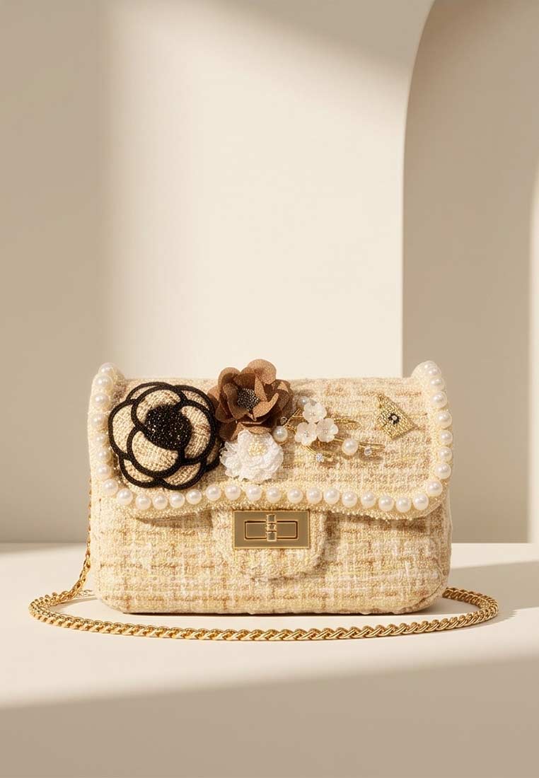 Schmuckzauber Tweed Trachtentasche Glamour beige. Frontansicht einer kleinen Umhängetasche aus beigem Tweed mit Perlenbesatz und Blumenapplikationen.