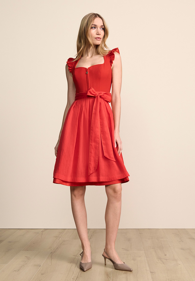 Frontansicht eines roten Dirndl Padme von Krüger mit Schürze und Riemchenärmeln. Das Dirndl hat einen herzförmigen Ausschnitt und einen Reißverschluss vorne.