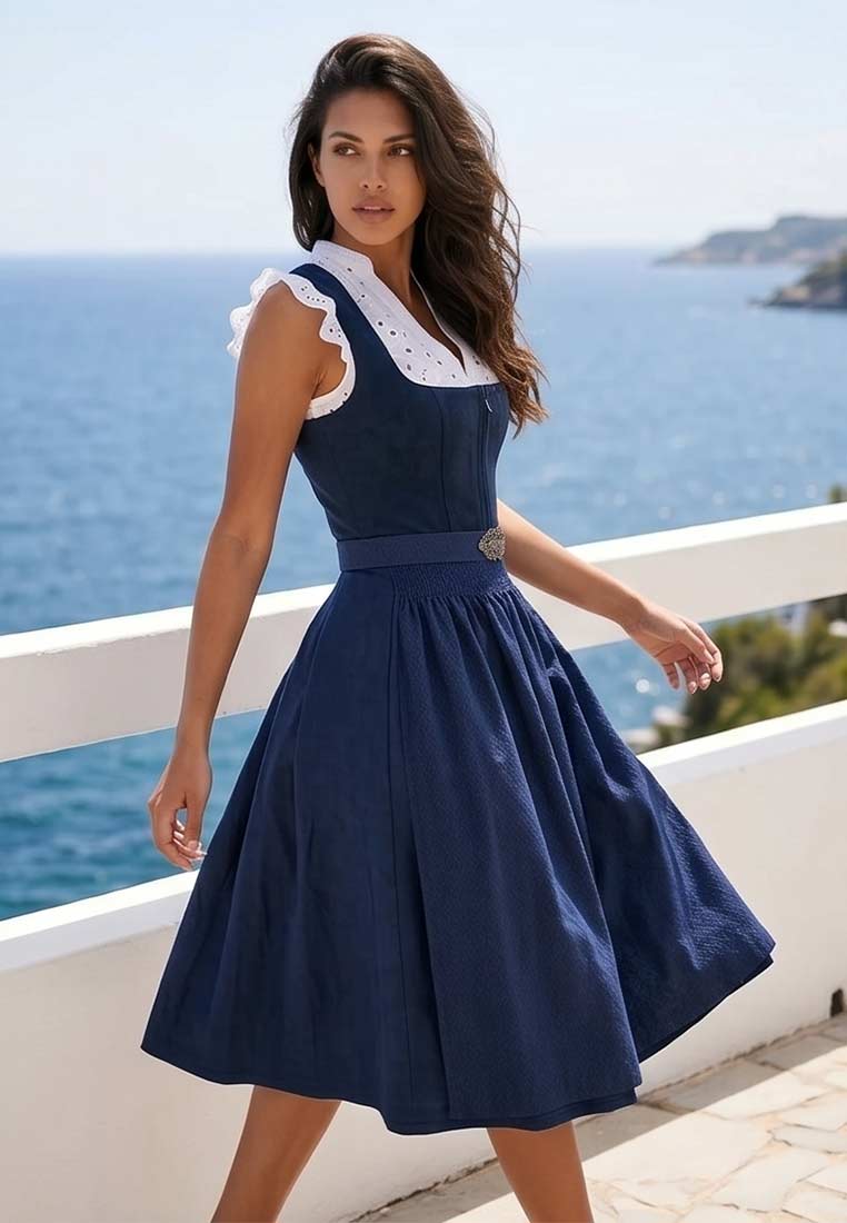Krüger Dirndl Alisha marine 60cm in Frontansicht. Das maritime Dirndl mit einem weißen Spitzenkragen und einer Schürze ist mit einem dezenten Muster verziert.