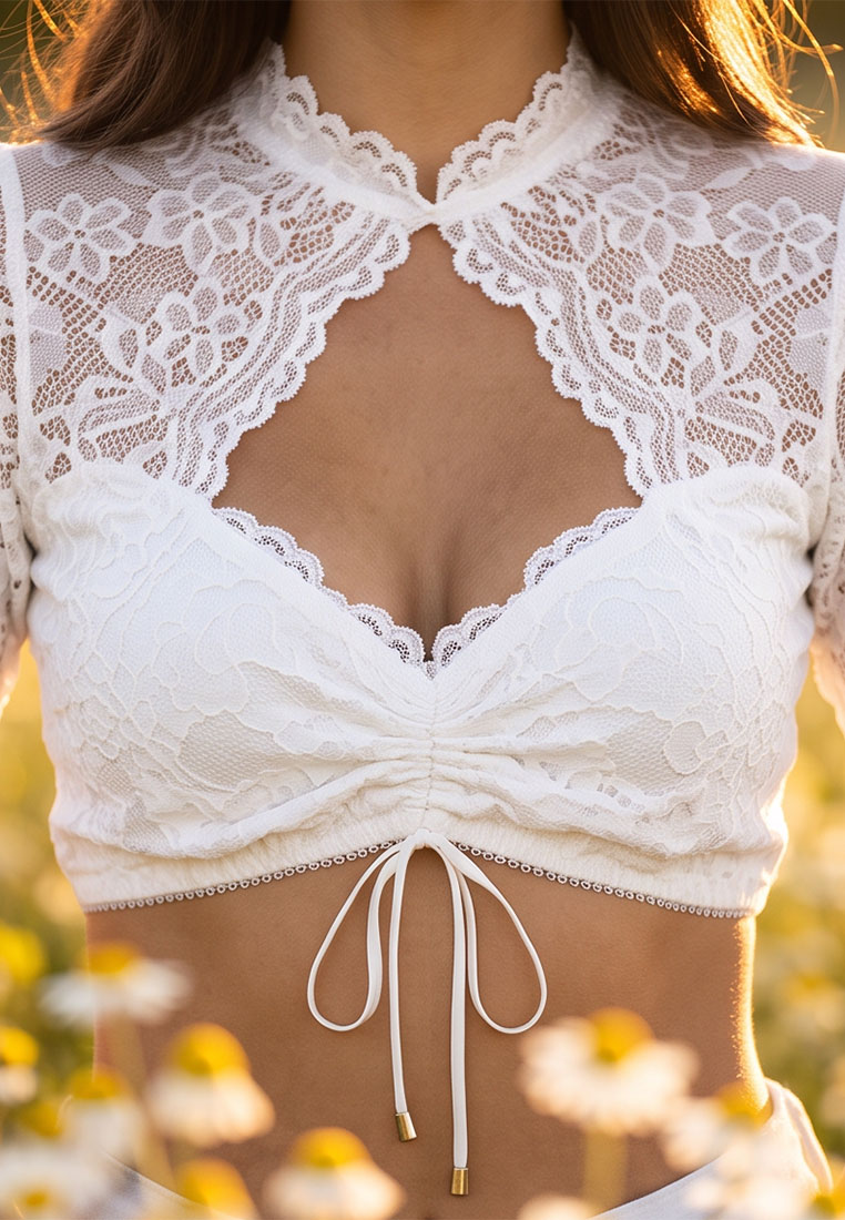 Nina von C. Dirndlbluse Sophie weiss: Detailansicht einer weißen Dirndlbluse aus Spitze mit Stehkragen und Schnürung am Bauch.