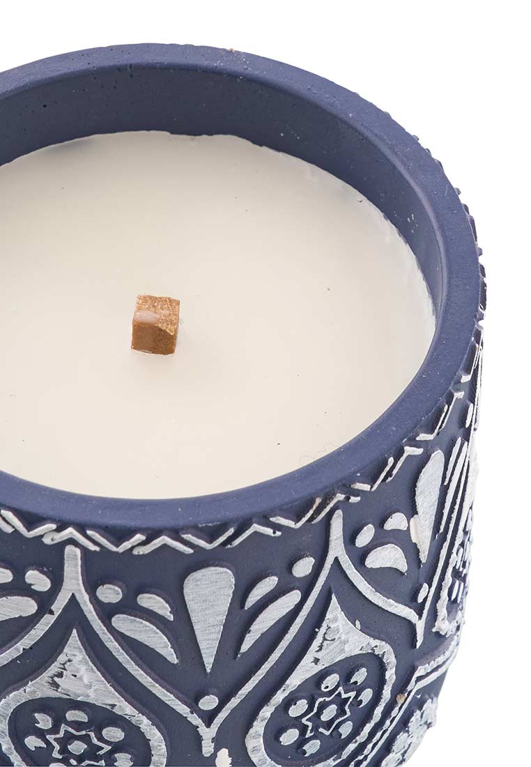 J-LINE Kerze Terracotta blau weiss, Detailansicht. Die Kerze in einem blauen Behälter mit weissem Wachs und sichtbarem Holzdocht zeigt eine gemusterte Oberfläche.