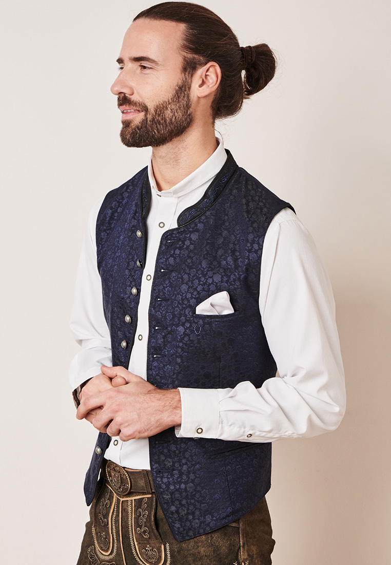Krüger Trachtenweste Juanito marine, seitliche Ansicht eines Mannes in dunkelblauer Trachtenweste mit Knopfleiste und einer Brusttasche mit Einstecktuch.