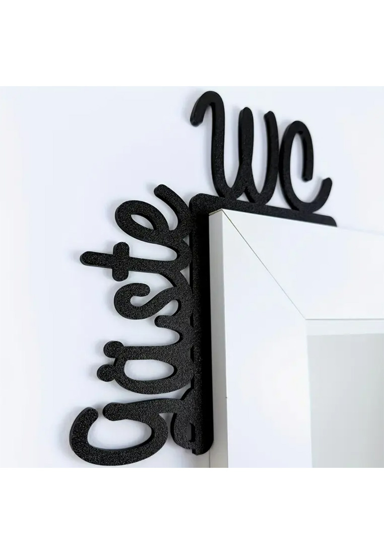 Schwarzes Schild "Gäste WC" von Schild, montiert an einer Wand über einem weißen Türrahmen, von vorne gesehen.