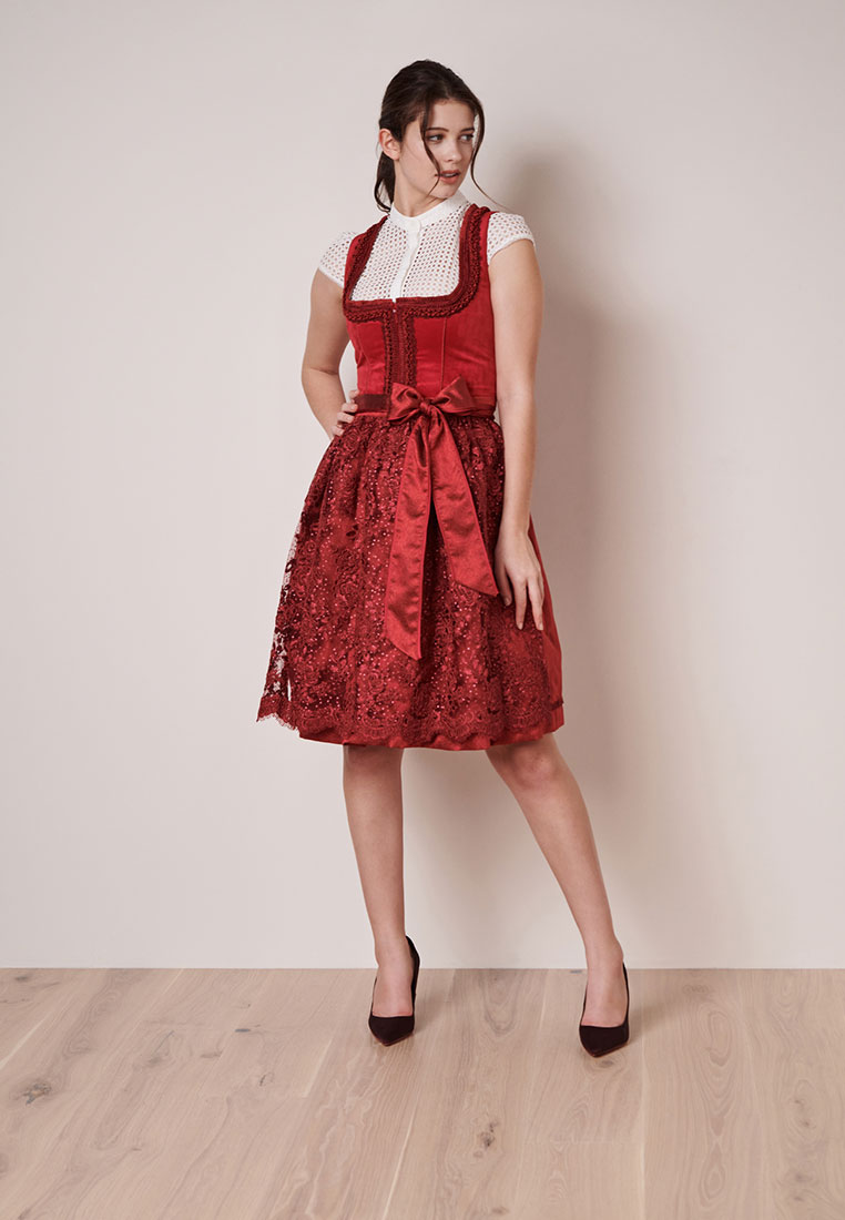 Frontansicht eines roten Dirndls Elma von Krüger mit Satinband und aufwendig besticktem Rockteil.