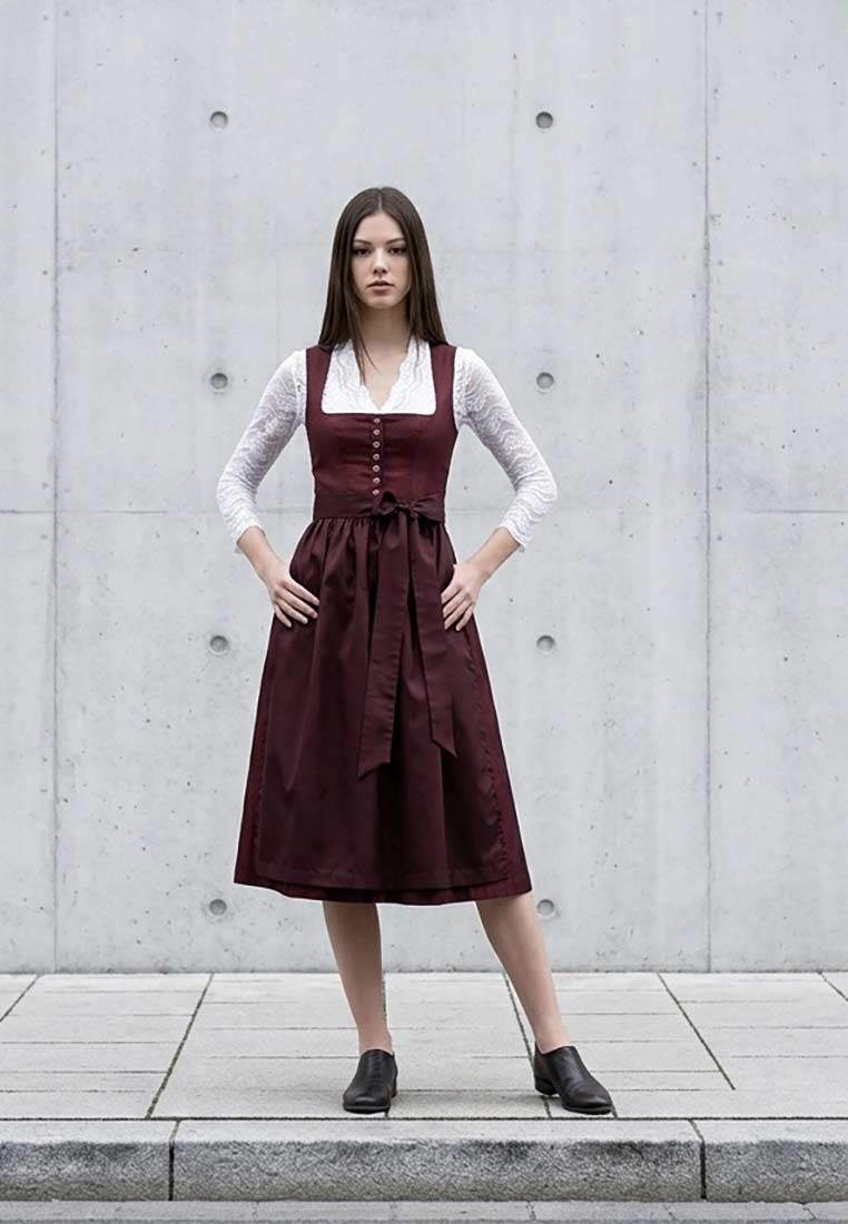 MarJo Trachten Dirndl Vordernberg kastanienrot 65 cm in Frontansicht. Das Dirndl hat eine gebundene Schleife und einen durchgehenden Knopfleisten-Verschluss. Das Kleid ist kastanienrot.
