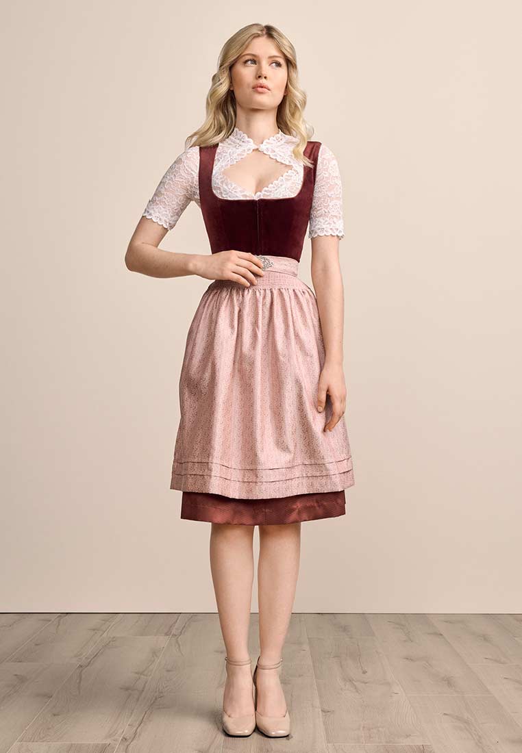 Krüger Dirndl Aurela bordeaux 60cm, Frontansicht. Das Dirndl hat ein bordeauxfarbenes Samt-Oberteil und eine rosafarbene Schürze mit Muster.
