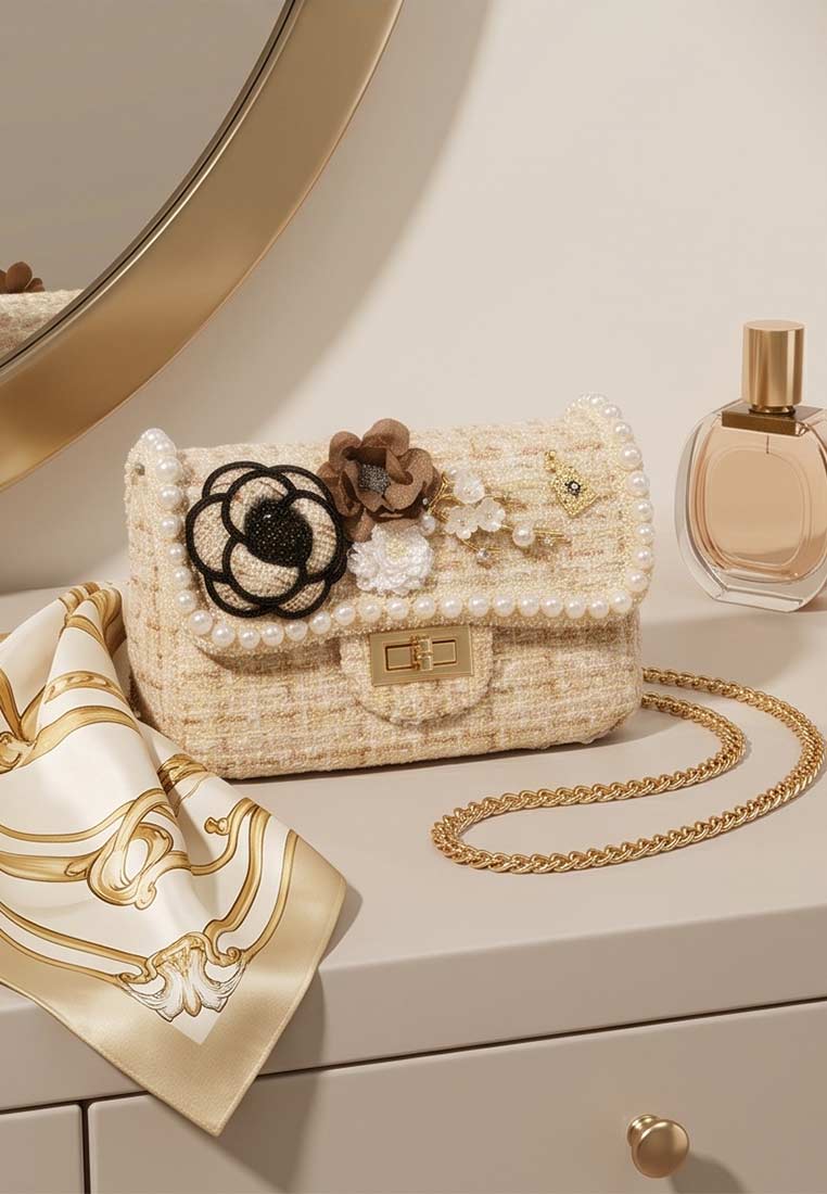 Schmuckzauber Tweed Trachtentasche Glamour beige, Frontansicht. Eine kleine, elegante Handtasche mit aufgesetzten Blumen und Perlenrand.