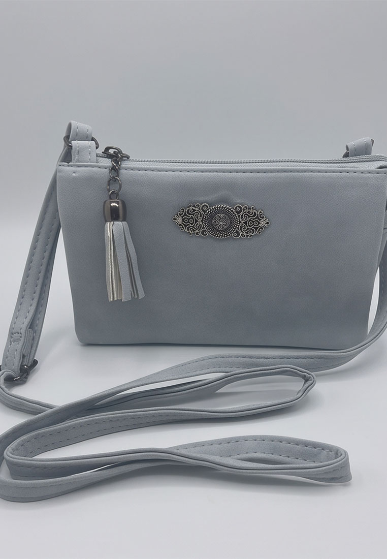 Taschenzauber Trachtentasche Marie hellblau, Frontansicht einer stilvollen hellblauen Tasche mit Reissverschluss und einem dekorativen Anhänger mit Quaste.
