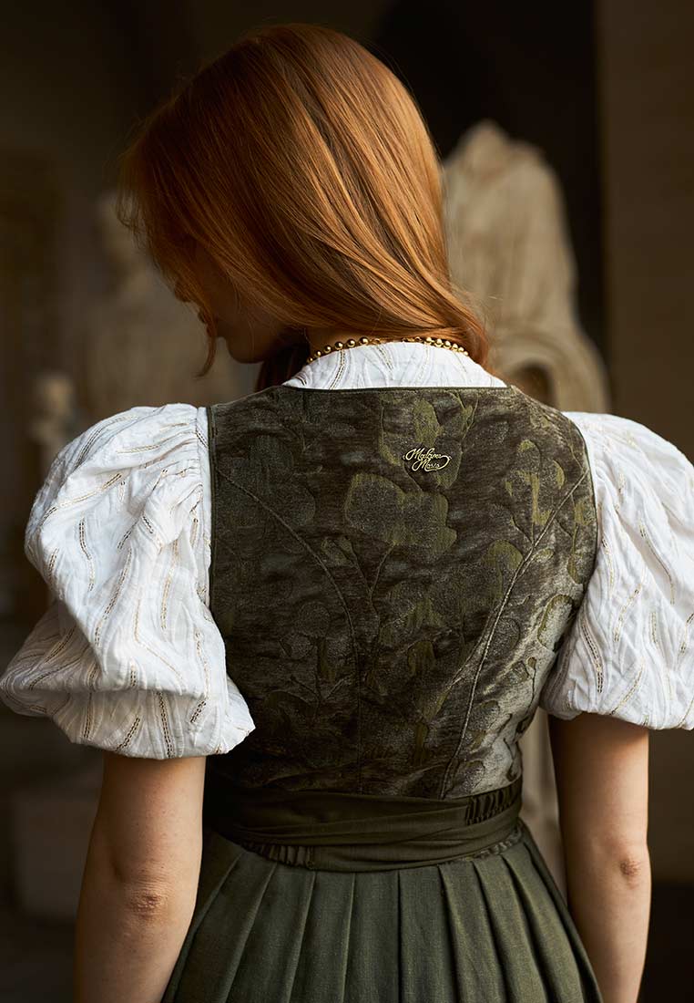 Madame Marie Dirndl Velirina Samt thymian 75 cm in Rückansicht. Das Dirndl ist thymianfarben mit Samt und hat eine weiße Puffärmelbluse mit goldenen Streifen.