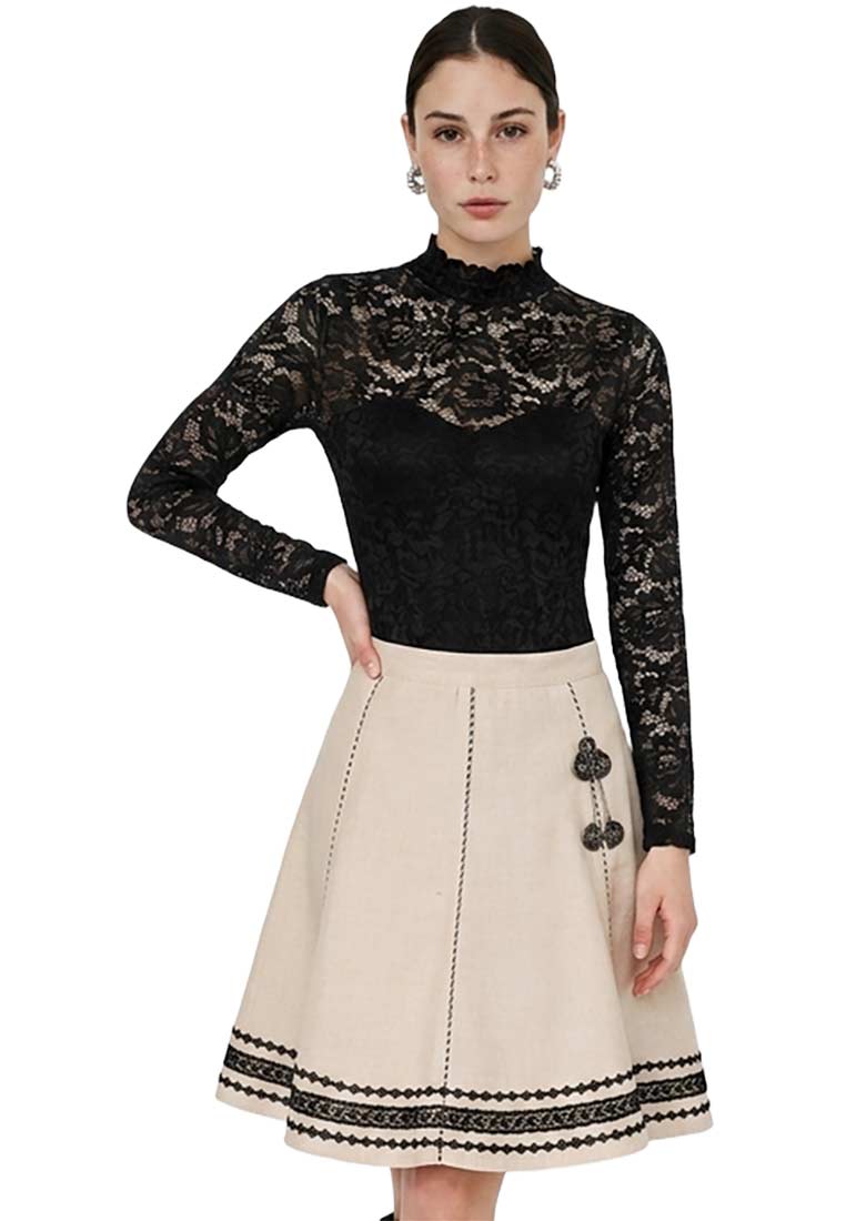 Marjo Trachtenrock Nora Asta in Beige von vorne, mit Stickereien und schwarzem Spitzenbesatz am Saum.
