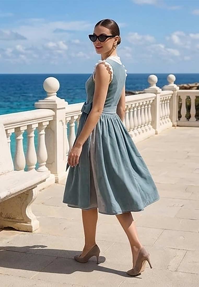Krüger Dirndl Yalara blau 70cm in Seitenansicht mit einem ausgestellten Rock und einer Schürze. Das Dirndl hat eine schlichte Waschung und einen runden Ausschnitt mit Spitzendetails.