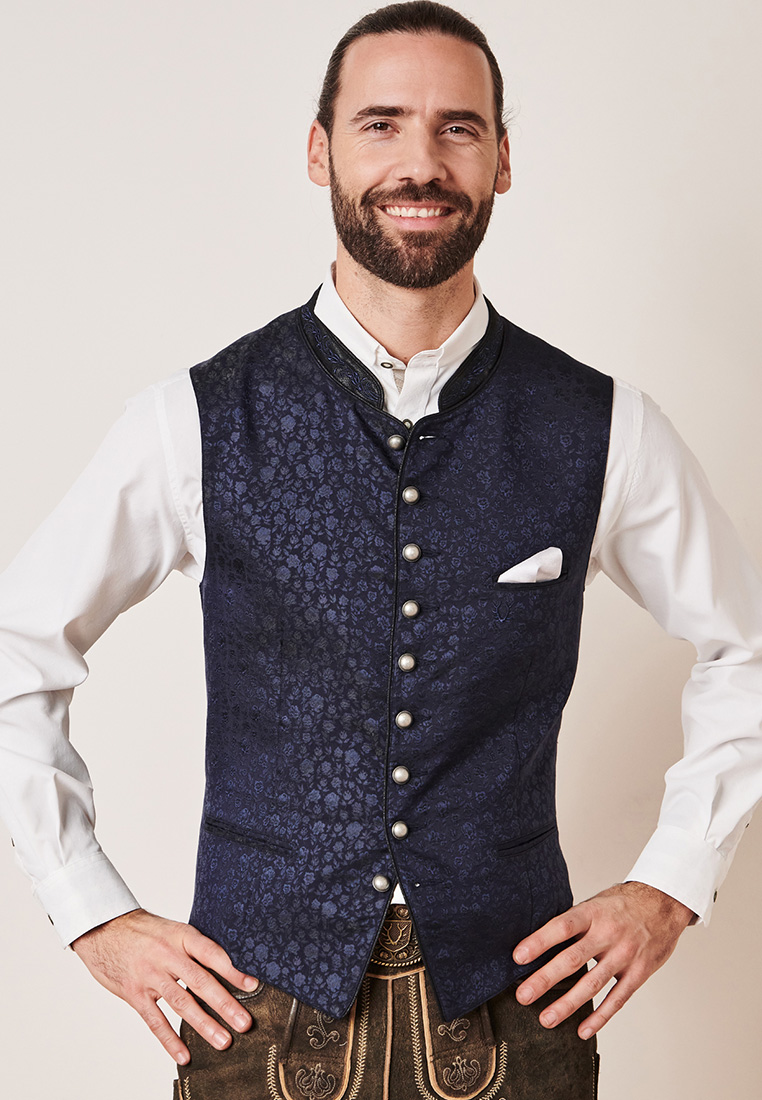 Krüger Trachtenweste Juanito marine. Frontansicht einer stilvollen blauen Trachtenweste mit dezentem Blumenmuster und silbernen Knöpfen.