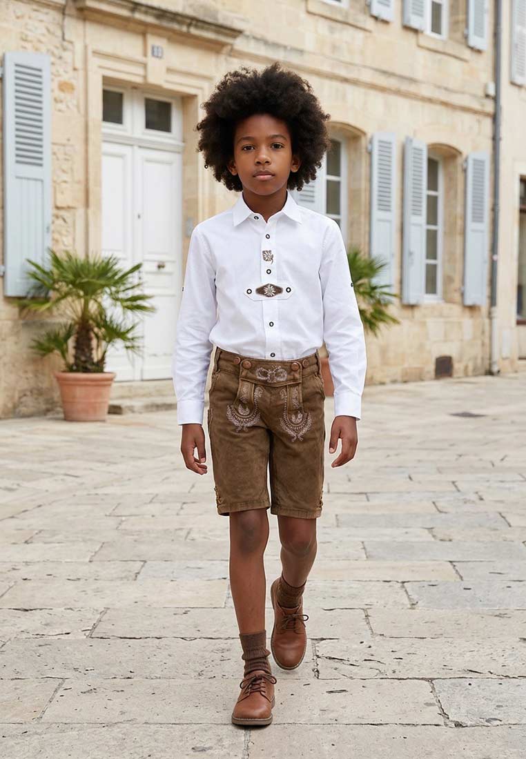 Hangowear Trachtenjeans Kids schlamm: Frontansicht eines Jungen in brauner Trachtenlederhose mit Stickerei und einem weißen Trachtenhemd.