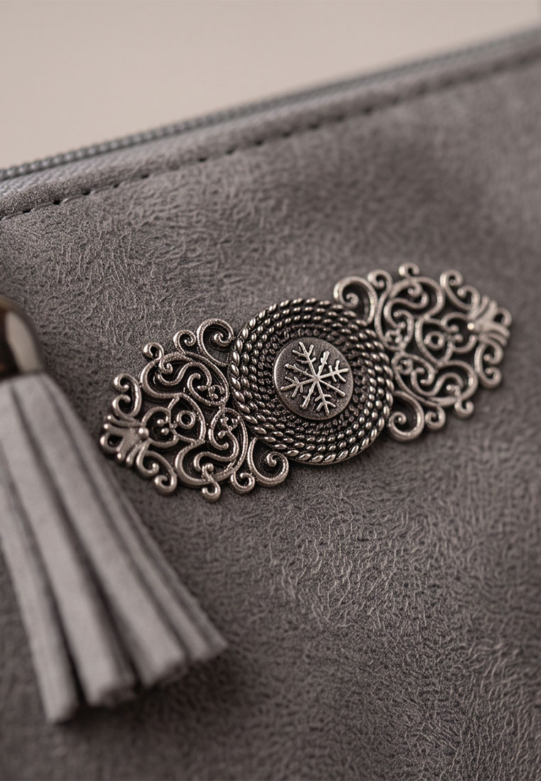Taschenzauber Trachtentasche Marie dunkelgrau, Detailansicht mit metallischer Applikation und Fransen, dunkelgraues Material.