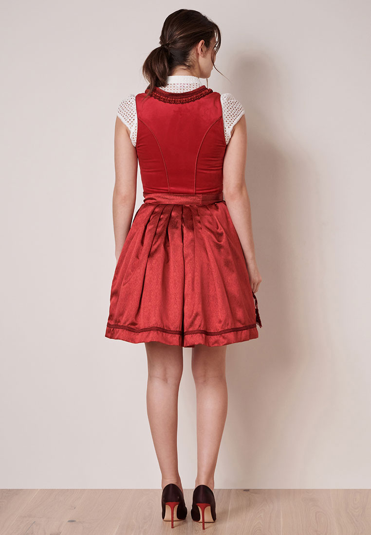 Rückansicht des roten Krüger Dirndls Elma mit detailreicher Fältelung und elegantem Schößchen. Das Dirndl zeigt einen V-Ausschnitt mit einer Häkelborte und kurze Ärmel mit Lochmuster.