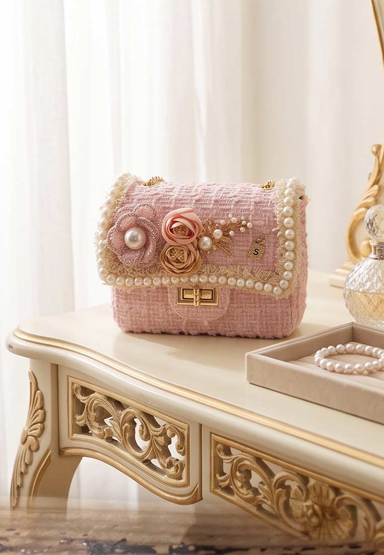 Schmuckzauber Tweed Trachtentasche Glamour rosa in Frontansicht mit Perlenbesatz und Blumenapplikation, die Tasche hat einen Schnappverschluss.