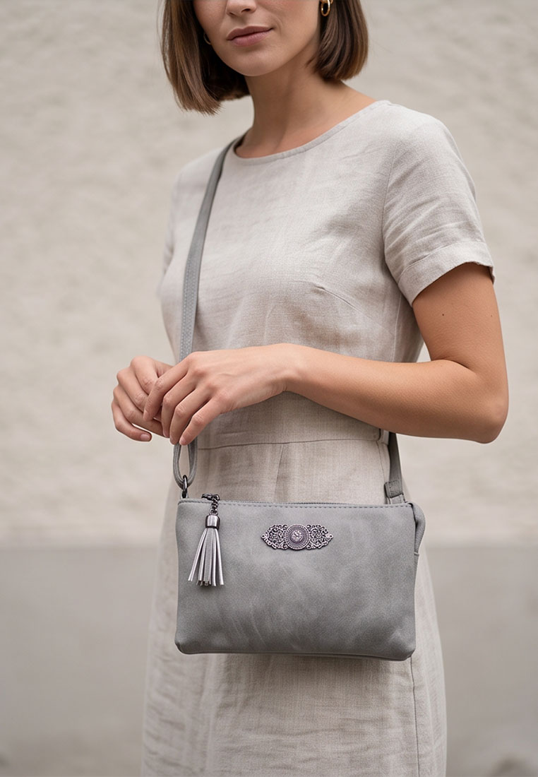 Taschenzauber Trachtentasche Marie grau Frontansicht einer grauen Handtasche mit Quaste und Zierapplikation.