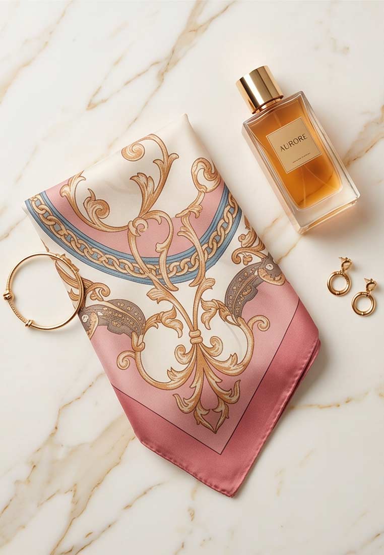 Schmuckzauber Nickituch Chains rosa mit ornamentalem Muster in Rosa, Gold und Blau, von vorne mit Schmuck und Parfum arrangiert.