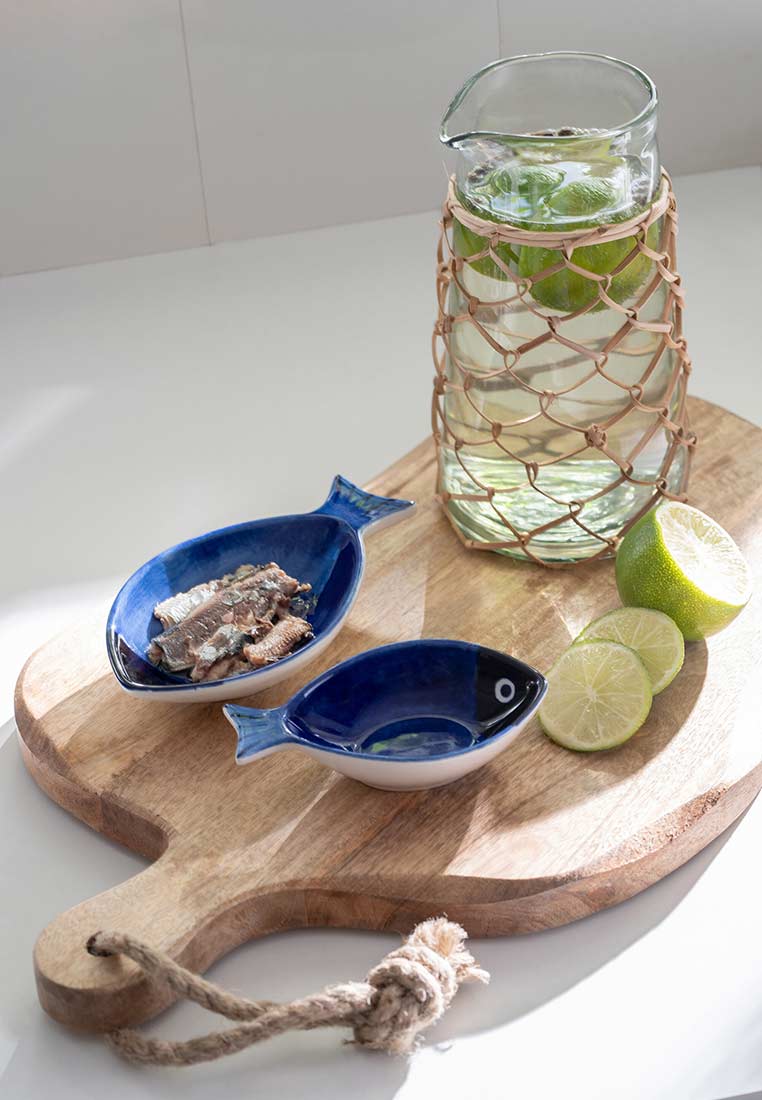 J-LINE Aperoschüssel Fisch Blau, Frontansicht. Die blaue Keramikschüssel in Fischform hat einen weißen Rand und ist mit einer glänzenden Glasur versehen.