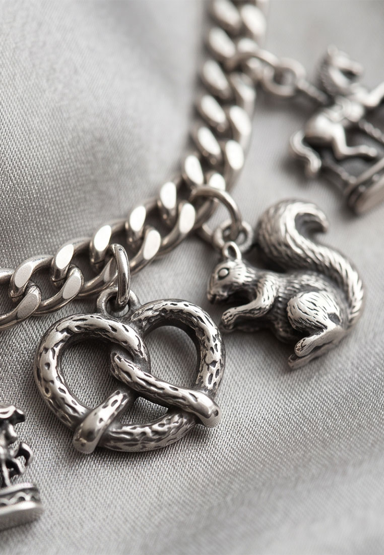 MarJo Trachten Dirndl Schürzenkette altsilber Vorderansicht mit Brezel- und Eichhörnchenanhänger. Die Kette ist aus poliertem Metall.