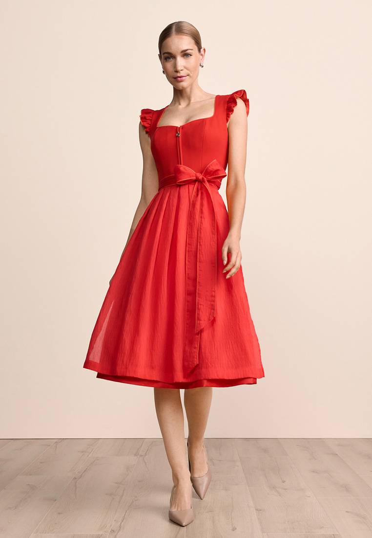 Krüger Dirndl Padme rot: Frontansicht eines roten Dirndls mit rüschenartigen Ärmeln und einer Schleife in der Taille.