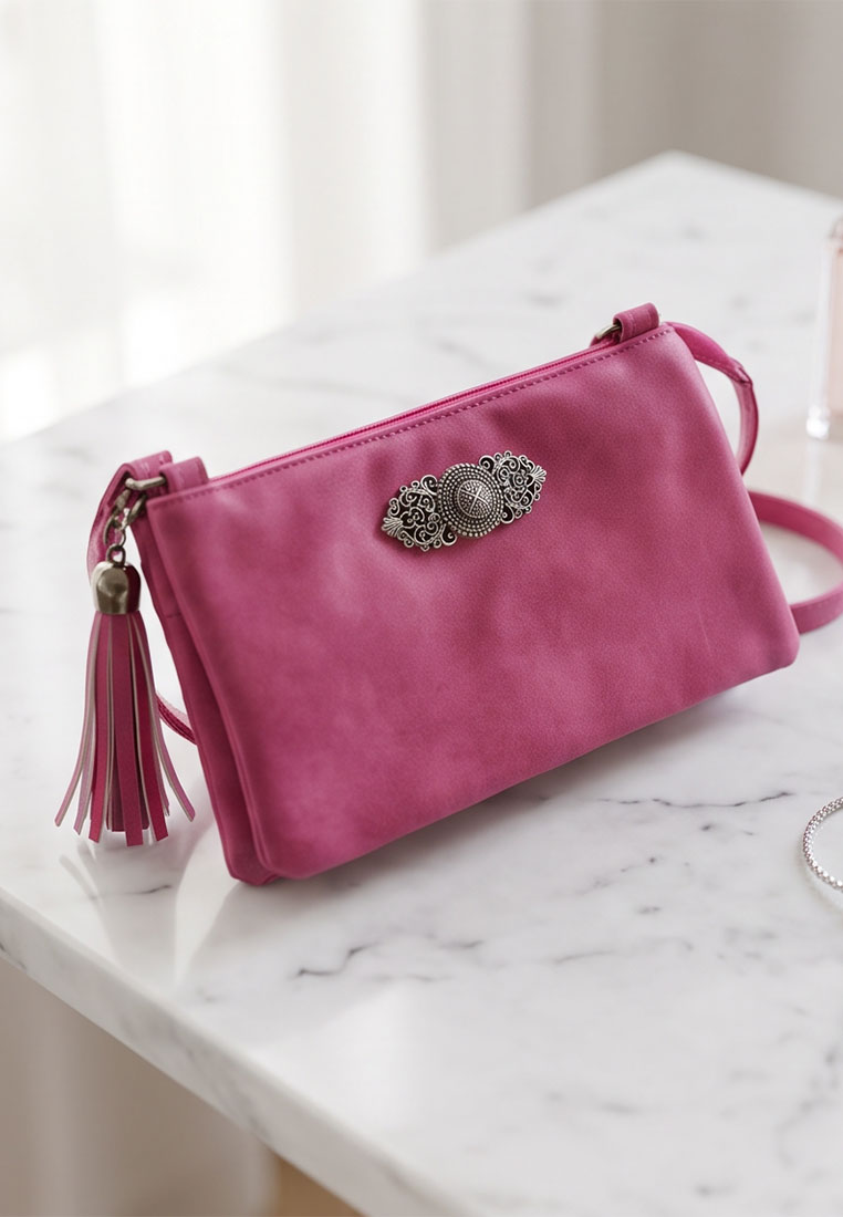 Taschenzauber Trachtentasche Marie fuchsia Frontansicht, eine stilvolle Tasche mit einem auffälligen Anhänger und einem separaten Quastenanhänger.
