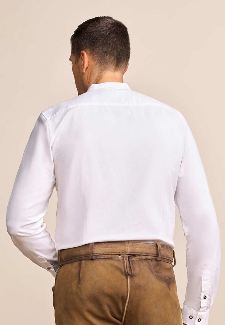 Rückansicht des Krüger Trachtenhemd Ryan in Weiss und Braun, mit Stehkragen und langen Ärmeln, das auf den braunen Lederhosen sitzt.